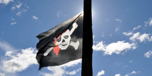 Bild på en piratflagga mot en blå himmel